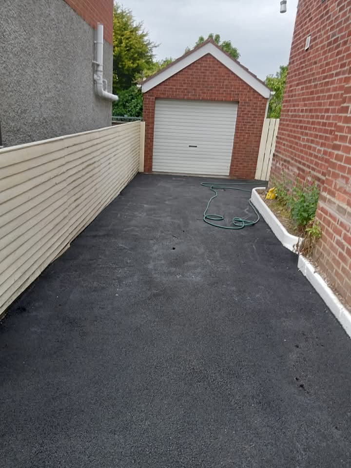 Tarmac driveway leading to brick garage